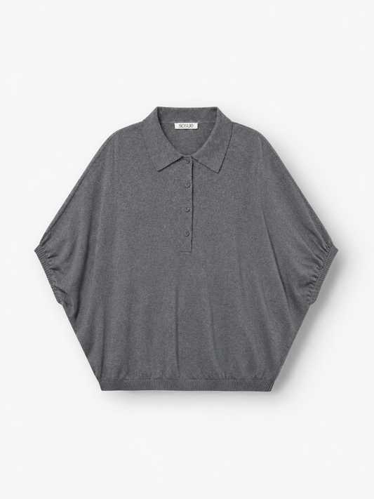 Ein graues Cowboy-Polo aus Feinstrick – kurzärmelig, mit Kragen, drei Knöpfen, lockerer Passform und geripptem Saum – wird flach auf weißem Hintergrund präsentiert. Dieses hochwertige Strick-Polo ist perfekt für alle, die raffinierten Komfort in einem Feinstrickpullover für Herren suchen, und bietet zeitlosen Stil für jeden Anlass.