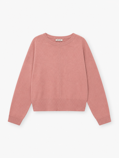 Der Pullover „Charly Altrosa“, ein rosa, langärmeliger Kaschmirpullover mit Rundhalsausschnitt sowie gerippten Bündchen und Saum, liegt flach auf einem weißen Hintergrund.