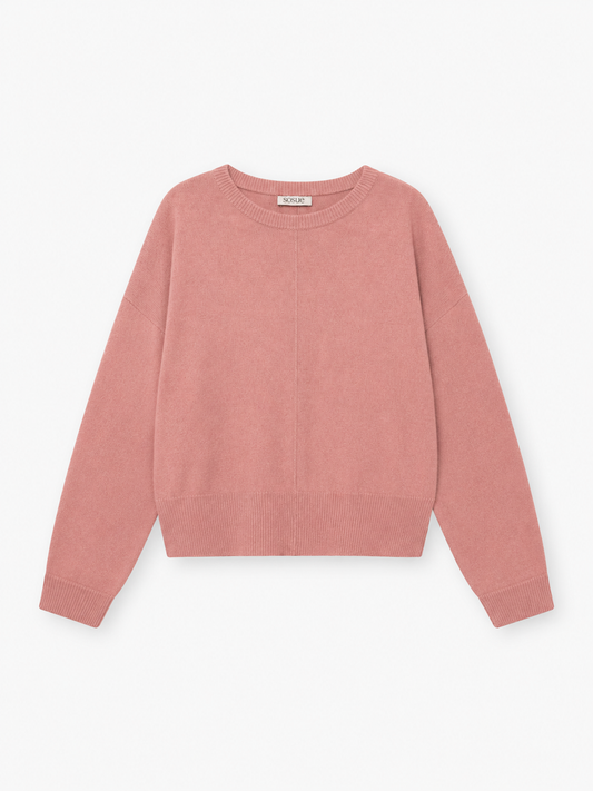 Der Pullover „Charly Altrosa“, ein rosa, langärmeliger Kaschmirpullover mit Rundhalsausschnitt sowie gerippten Bündchen und Saum, liegt flach auf einem weißen Hintergrund.