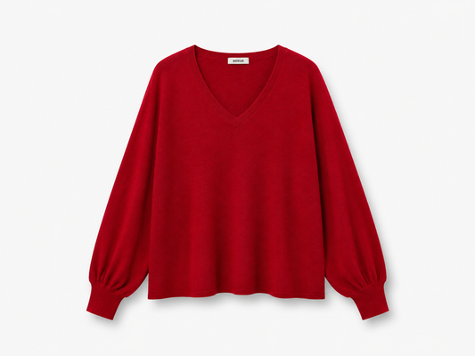 Der Pullover „Antonia“ mit V-Ausschnitt in Rot verfügt über lange, locker sitzende Ärmel und gerippte Bündchen und vereint Komfort mit Stil. Dieser elegante rote Pullover aus Merinowolle wird vor einem schlichten weißen Hintergrund präsentiert, wodurch sein raffiniertes Design besonders zur Geltung kommt.