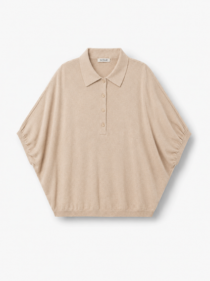 Cowboy Polo Knit Powder: Ein kurzärmeliges, locker sitzendes Strickoberteil in Puderbeige mit Polokragen und Knopfleiste, abgebildet vor einem schlichten weißen Hintergrund.