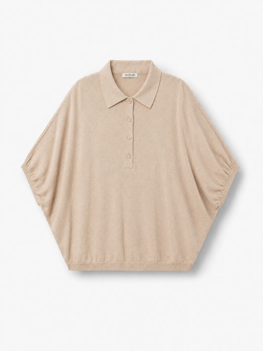 Cowboy Polo Knit Powder: Ein kurzärmeliges, locker sitzendes Strickoberteil in Puderbeige mit Polokragen und Knopfleiste, abgebildet vor einem schlichten weißen Hintergrund.