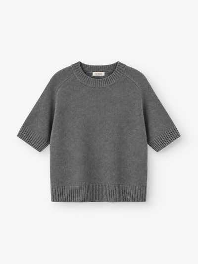 Joana T-Shirt: Ein graues, kurzärmeliges Strick-T-Shirt mit gerippten Bündchen, Saum und Kragen, gefertigt aus einer luxuriösen Merinowolle-Mischung und auf weißem Hintergrund abgebildet.