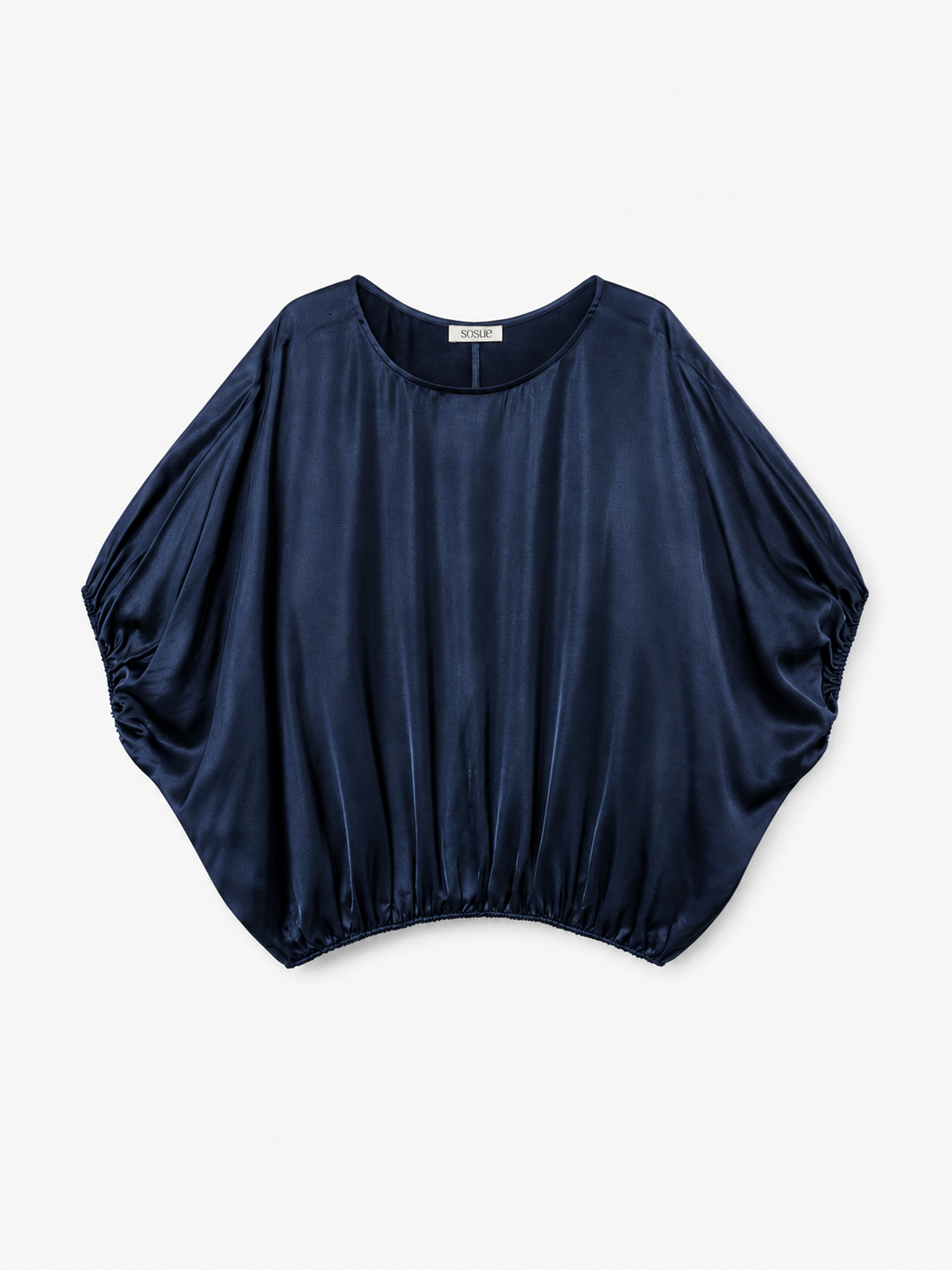 Die „Bluse Cowboy Shiny Navy“ ist eine marineblaue, kurzärmelige Damenbluse aus Satin mit lockerer, drapierter Passform und elastischem Saum. Diese Oversize-Bluse verfügt über einen abgerundeten, weiten Ausschnitt und besticht durch eine glänzende, glatte Oberfläche, die für einen mühelos eleganten Look sorgt.