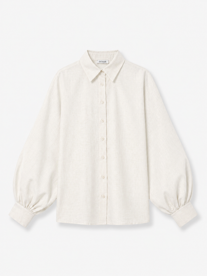 Die Bluse „Antonia Slim Flannel Offwhite“ ist ein langärmeliges, cremefarbenes Hemd aus hochwertiger Baumwolle mit klassischem Kragen, breiten Manschetten und leicht gepufften Ärmeln, flach auf einem weißen Hintergrund liegend.