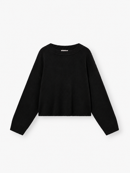 Ein schlichter schwarzer Langarm-Strickpullover mit Rundhalsausschnitt vor weißem Hintergrund. Der Pullover „Giulia Schwarz“ für Damen besticht durch eine lockere, leicht verkürzte Passform und schlichte, klare Linien.