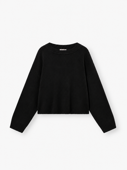 Ein schlichter schwarzer Langarm-Strickpullover mit Rundhalsausschnitt vor weißem Hintergrund. Der Pullover „Giulia Schwarz“ für Damen besticht durch eine lockere, leicht verkürzte Passform und schlichte, klare Linien.