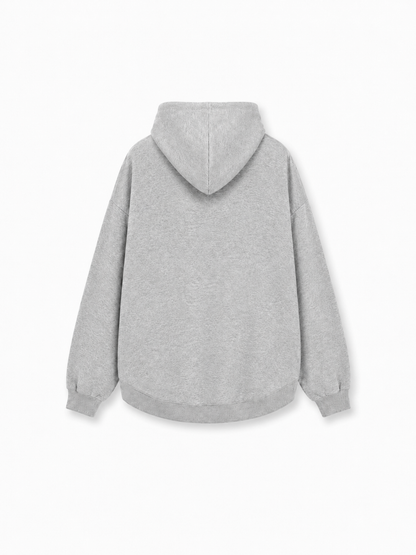 Der Grauer Oversized-Hoodie wird von hinten vor einem weißen Hintergrund gezeigt. Dieser schlichte, hellgraue Hoodie hat eine lockere, Oversized-Passform mit Kapuze und langen Ärmeln mit Bündchen für höchsten Tragekomfort. Das Design ist minimalistisch, ohne sichtbare Logos oder Verzierungen.