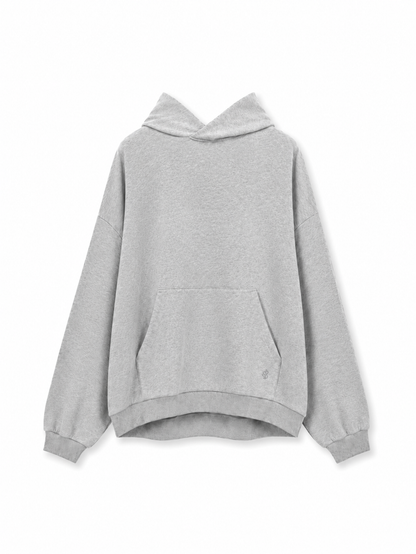 Der „Grauer Oversized Hoodie“ ist ein hellgrauer, übergroßer Hoodie mit langen Ärmeln, einer Brusttasche und gerippten Bündchen, der in Portugal hergestellt wurde und hier vor weißem Hintergrund abgebildet ist.