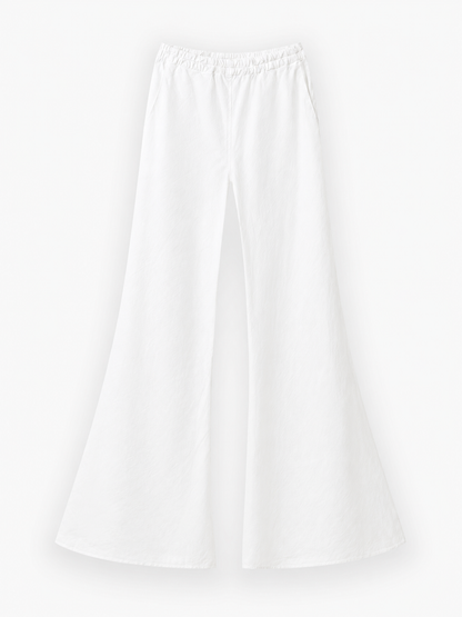 Weiße Hose „Joana White“ mit weitem Bein, elastischem Bund und Seitentaschen, präsentiert vor einem schlichten weißen Hintergrund. Diese weiße Leinenhose besticht durch ihre ausgestellte Silhouette und den leichten Stoff und ist damit die perfekte Sommerhose für Damen für einen lässigen Sommerlook.