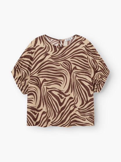 Das Cowboy Shirt Zebra Brown ist eine kurzärmelige Bluse mit abstraktem Zebramuster in Braun und Beige, Rundhalsausschnitt und gerafften Ärmeln.