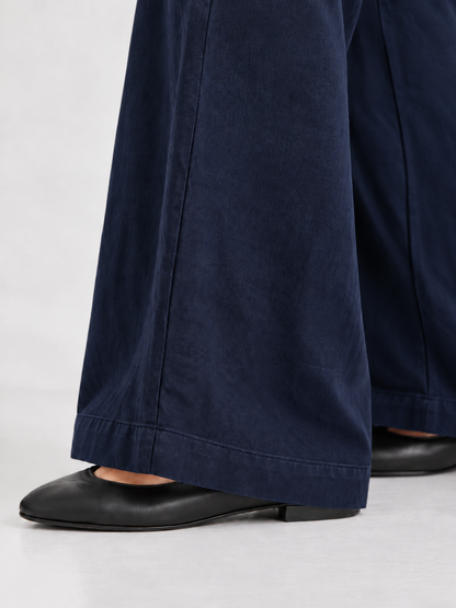 Hose Josy Linen Navy – weit geschnittene Hose, kombiniert mit schwarzen flachen Schuhen.