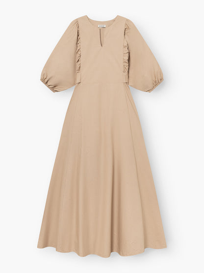Das Kleid Antonia Lang zeigt feminine Eleganz in Beige mit ellenbogenlangen Puffärmeln, dezenten Rüschen, einer taillierten Passform und einem fließenden, bodenlangen ausgestellten Rock.