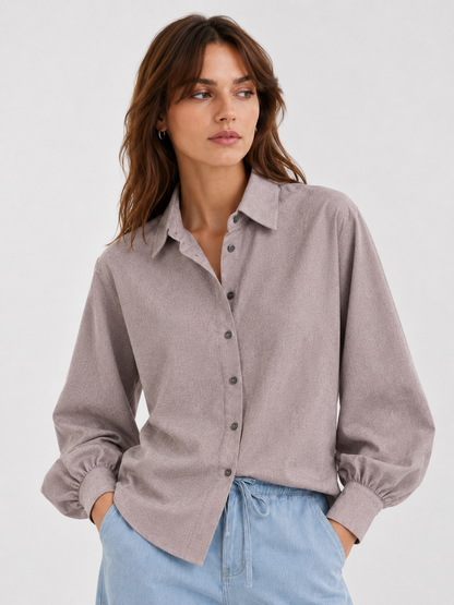 Frau, die eine Bluse Antonia Slim Flannel Taupe mit Knopfmanschetten und eine blaue Jeans trägt.
