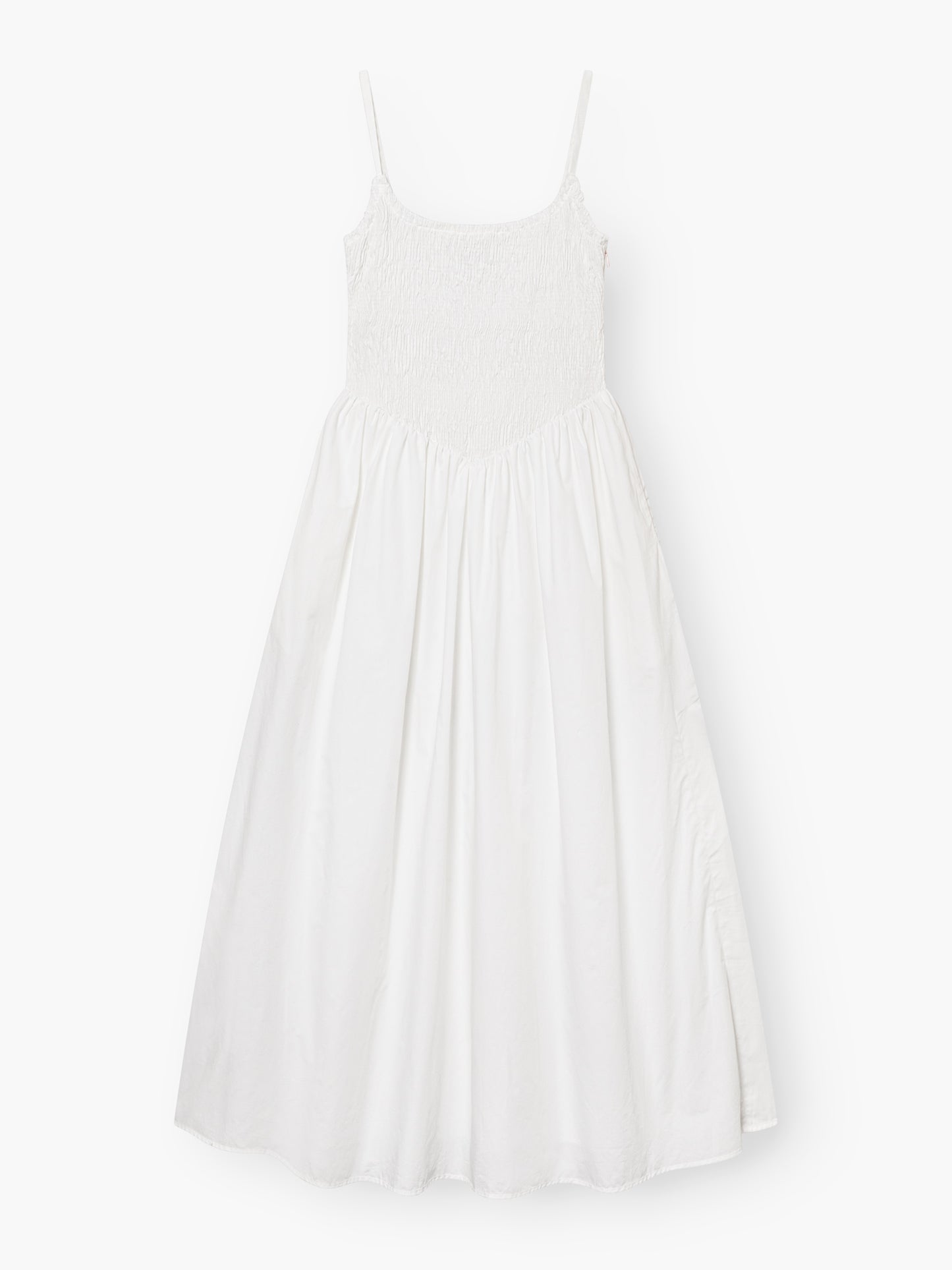 Das Elisa Dress White ist ein ärmelloses Kleid mit Spaghettiträgern, einem gesmokten Mieder und einem fließenden, gerafften Rock, der flach auf weißem Grund liegt.