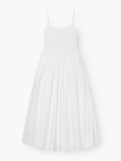 Das Elisa Dress White ist ein ärmelloses Kleid mit Spaghettiträgern, einem gesmokten Mieder und einem fließenden, gerafften Rock, der flach auf weißem Grund liegt.