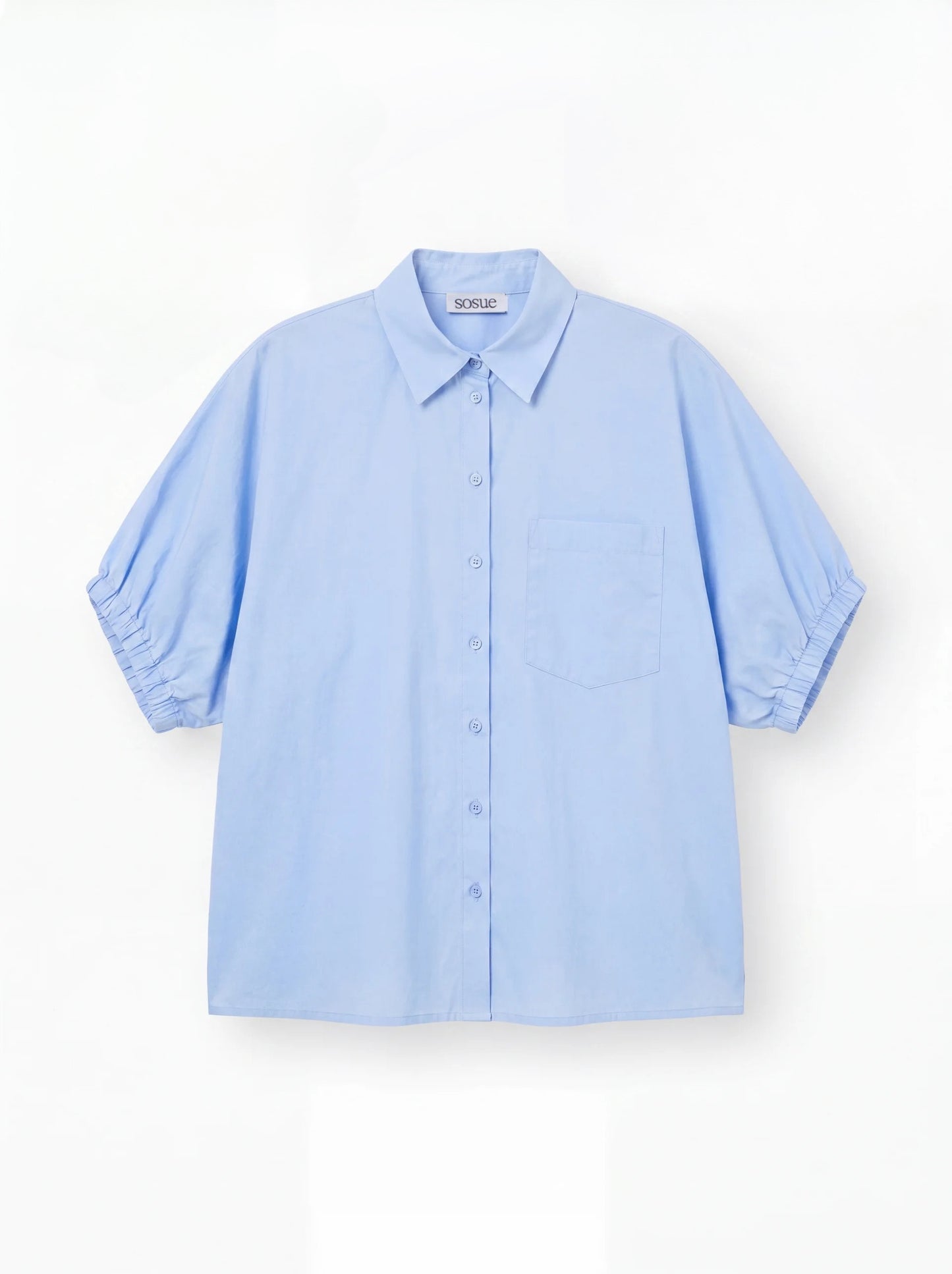 Das Cowboy Collar Voile Light Blue ist ein locker sitzendes, kurzärmeliges Button-up-Hemd mit Kragen und einer Brusttasche, das in Hellblau auf weißem Grund gehalten ist.