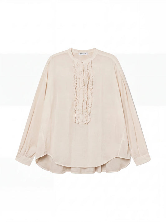 Die Bluse Bruna Beige ist eine langärmelige, cremefarbene Bluse mit Rundhalsausschnitt und zarten Rüschen auf der Vorderseite, die auf einem einfarbig weißen Hintergrund zu sehen ist.