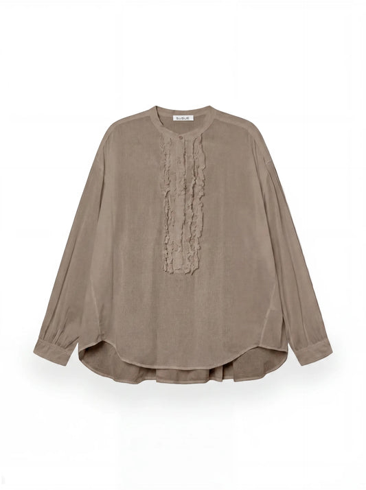 Die Bluse Bruna Soft Brown ist ein langärmeliges, locker sitzendes Oberteil mit rundem Halsausschnitt und dezenten vertikalen Rüschendetails auf der Vorderseite, die auf einem schlichten weißen Hintergrund zu sehen sind.