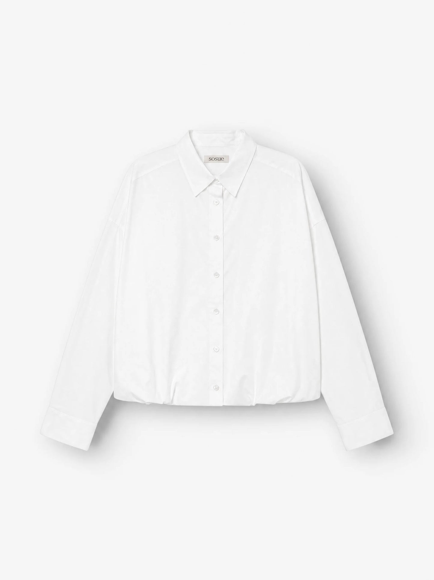 Die „Ballon Blouse White“ besticht durch ihre strahlend weiße Farbe, lange Ärmel, einen klassischen Kragen, eine leicht übergroße Passform und überschnittene Schultern und wird vor einem schlichten weißen Hintergrund präsentiert.