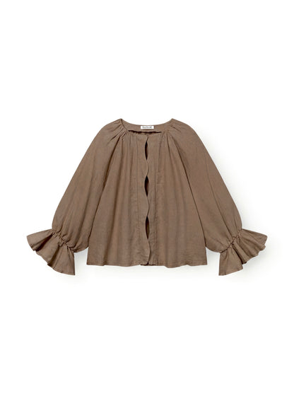 Die Bluse „Wave Linen Soft Brown“ ist eine locker sitzende, langärmelige Bluse mit gerüschten Ärmelbündchen und gewellten Details an der Vorderseite, die eine feminine Silhouette schaffen; abgebildet vor weißem Hintergrund.