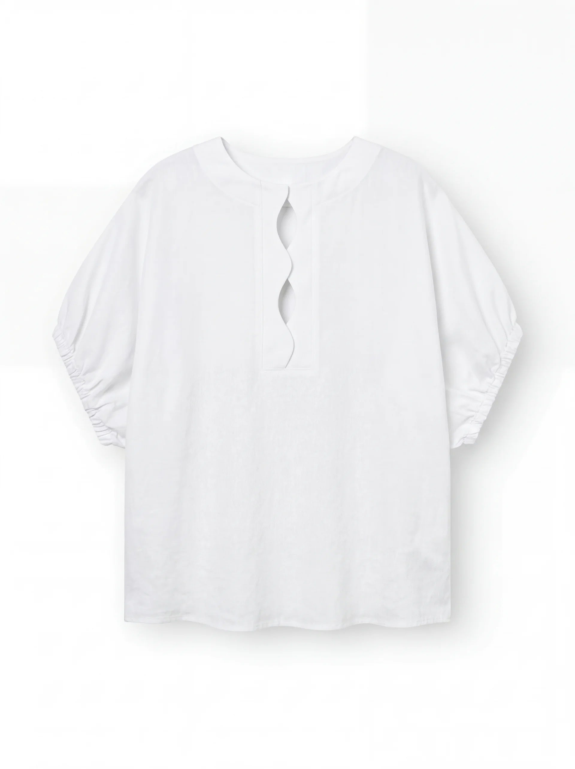 Die Bluse Cowboy Wave Linen White ist eine locker sitzende weiße Leinenbluse mit ellenbogenlangen gerafften Ärmeln, einem überschnittenen Schlüssellochausschnitt im Rücken und dezenten Wellendetail-Akzenten.