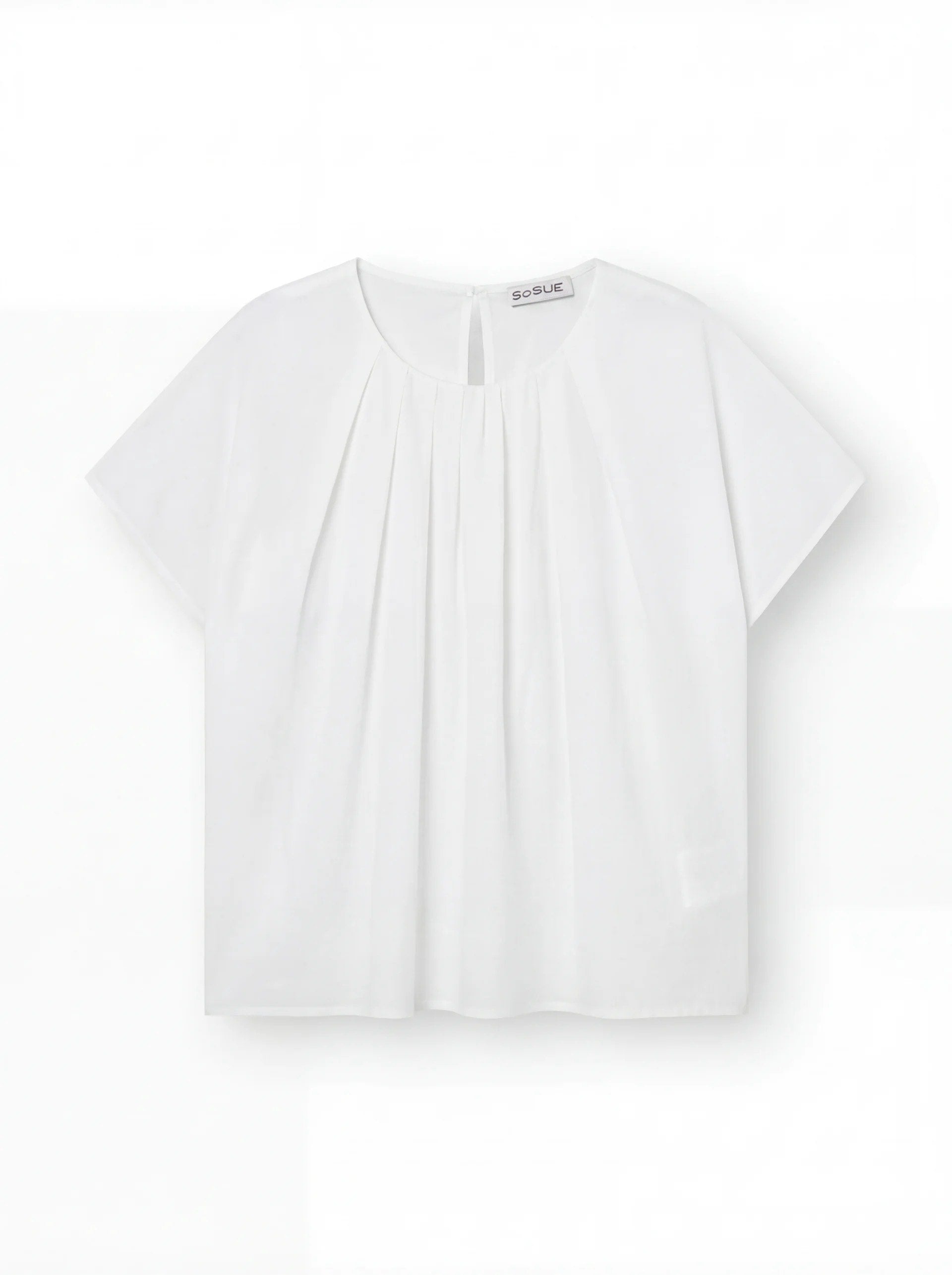 Die Bluse Tulip White hat kurze Ärmel, einen Rundhalsausschnitt, Falten auf der Vorderseite und eine lockere, kastenförmige Passform, die vor einem einfarbig weißen Hintergrund gezeigt wird.