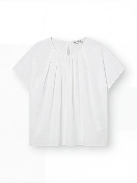 Die Bluse Tulip White hat kurze Ärmel, einen Rundhalsausschnitt, Falten auf der Vorderseite und eine lockere, kastenförmige Passform, die vor einem einfarbig weißen Hintergrund gezeigt wird.