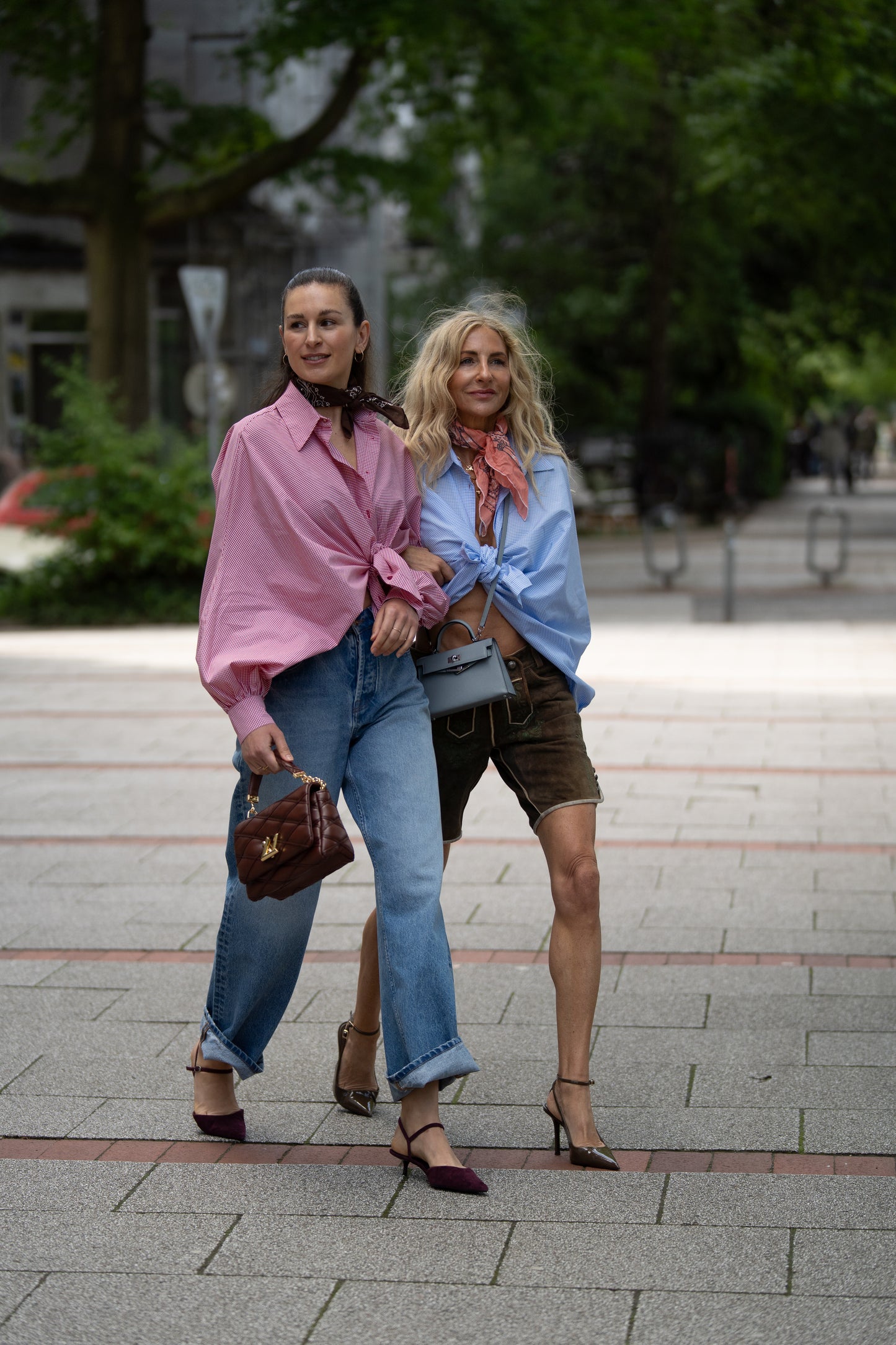 Zwei Frauen posieren für ein Foto, beide tragen die stilvolle Bluse Antonia Brezel Blue - eine in klassischem Blau-Karo - und zeigen ihren Sinn für Mode in der Limited Edition.