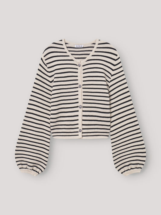 Jacke Fiene ist eine cremefarbene, kurz geschnittene maritime Strickjacke mit schwarzen Streifen, Knöpfen vorne, leicht gepufften langen Ärmeln mit gerafften Bündchen und rundem Halsausschnitt. Sie liegt flach auf einem hellen Untergrund.