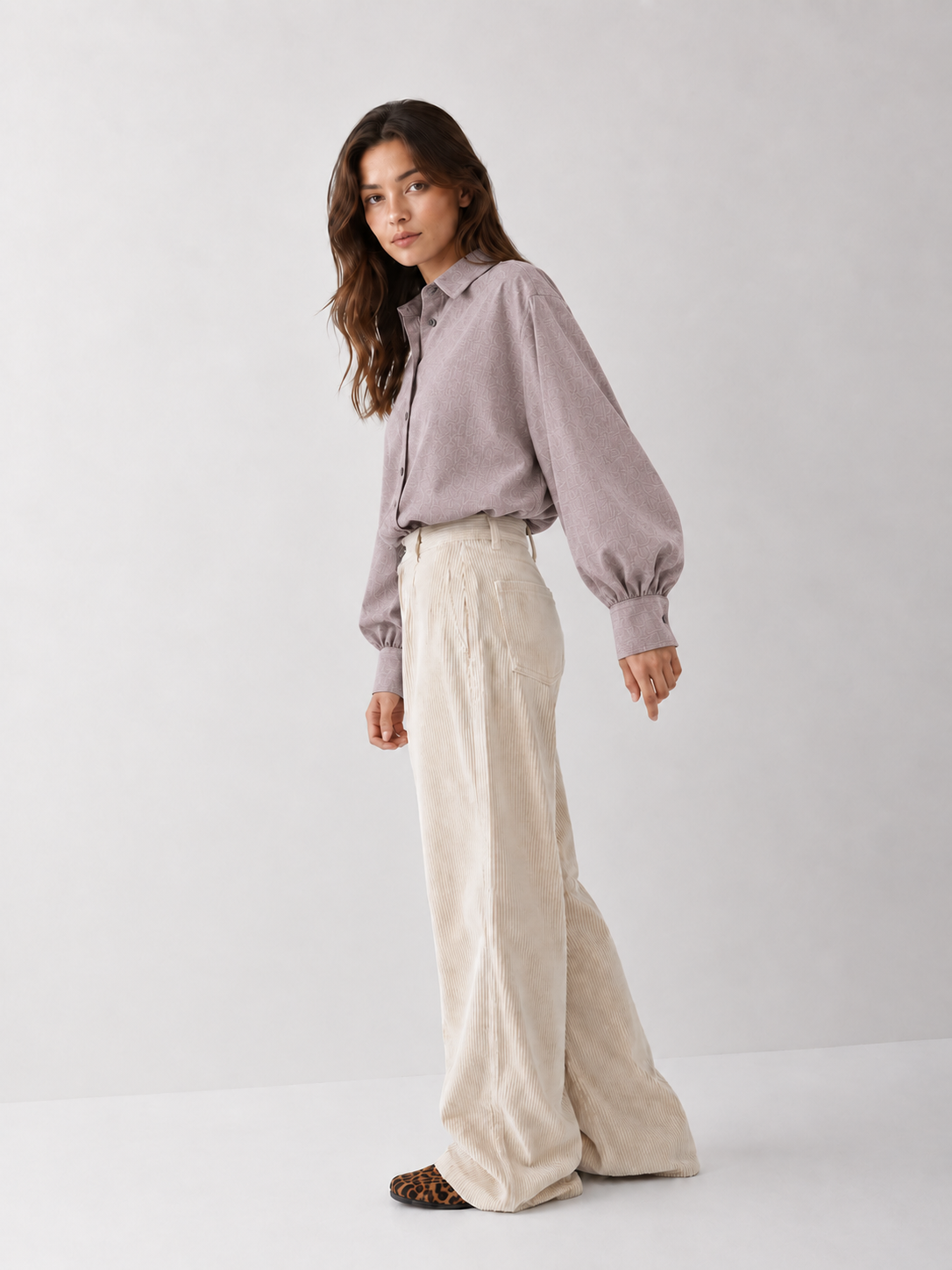 Eine Frau trägt ein taupefarbenes Bluse Antonia Slim Flannel-Hemd, das sie in eine cremefarbene Cordhose mit weitem Bein gesteckt hat.