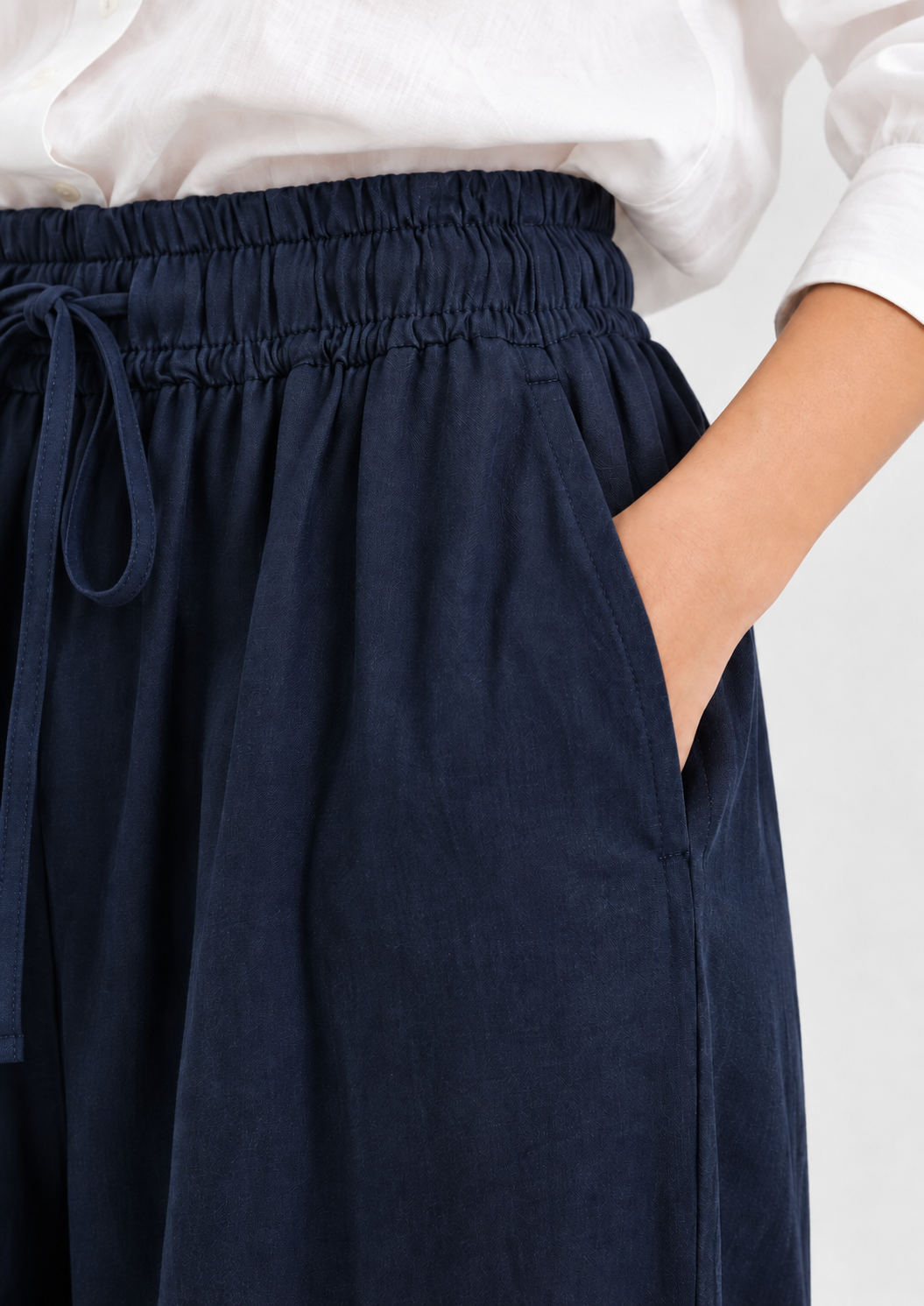 Hose Josy Linen Navy: marineblaue Baumwollhose mit weitem Schnitt, elastischem Bund mit Kordelzug und einer Seitentasche.