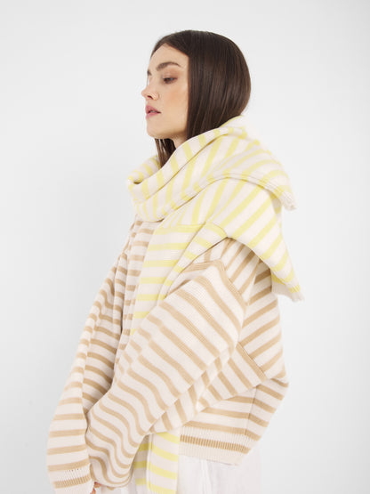 Eine Frau mit glattem braunem Haar trägt den Pullover Sailor Beige Offwhite, der vor einem schlichten weißen Hintergrund steht.