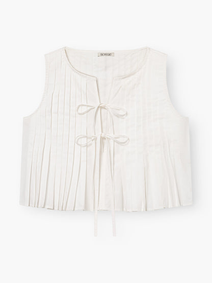 Das Top Cleo Weiss ist eine ärmellose weiße Weste mit Rundhalsausschnitt, zwei Bindebändern auf der Vorderseite, dezenten vertikalen Falten und einem leichten, leicht taillierten Design.