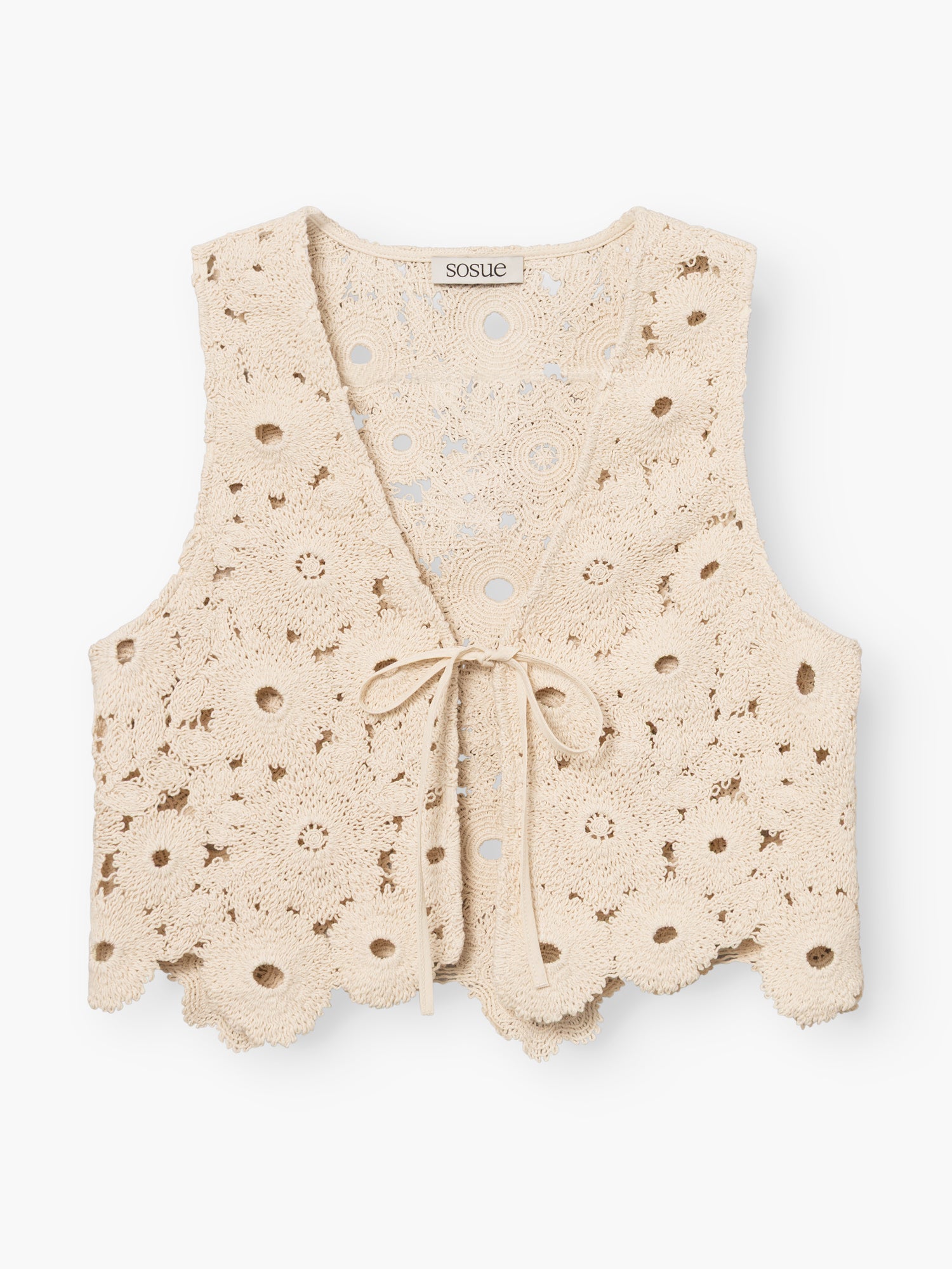 Die Vest Ibiza ist eine cremefarbene Häkelweste mit überschnittenem Saum, Blumenmuster, ärmellosem Design, Bindeverschluss vorne und einem SOSUE-Label am Halsausschnitt.