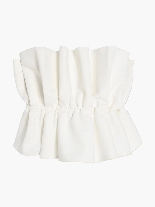 Das Pleat Top White ist ein weißes, schulterfreies Crop-Top mit geraffter Faltenoptik und ausgestelltem Saum, das auf einem einfarbig weißen Hintergrund gezeigt wird.