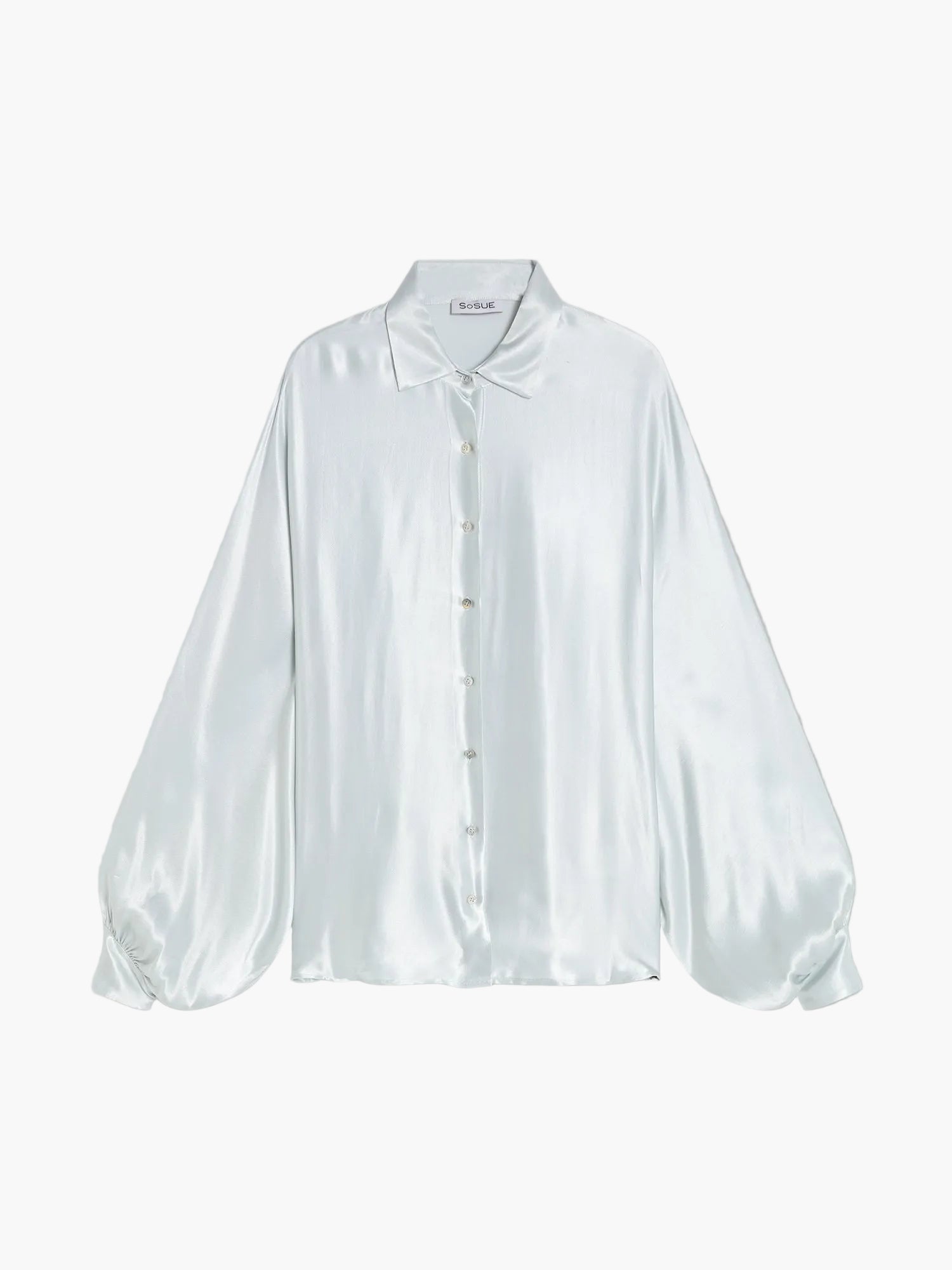 Die Bluse Antonia Shiny IceGrey ist eine übergroße Damenbluse aus hellblauem Satin mit spitzem Kragen, geknöpfter Vorderseite und weiten Ärmeln, die an den Manschetten gerafft sind, abgebildet auf einem einfarbigen hellgrauen Hintergrund.