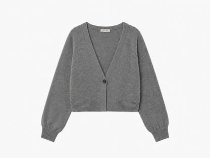 Der kurze Cardigan „Antonia“ in Grau ist ein kurz geschnittener Damen-Cardigan mit langen Ärmeln aus feinem Strick, einem tiefen V-Ausschnitt und einem einzelnen Knopfverschluss vorne, der sorgfältig auf weißem Hintergrund angeordnet ist.