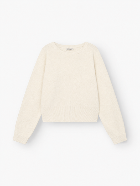 Ein langärmeliger Pullover „Charly“ in Offwhite mit Rundhalsausschnitt sowie gerippten Bündchen und Saum liegt flach auf einem weißen Hintergrund.