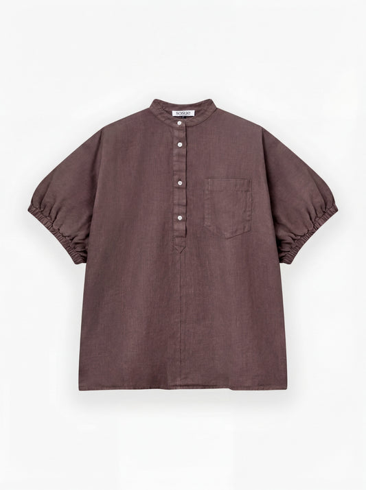 Die Cowboy Button Linen Brown ist eine locker sitzende, kurzärmelige Bluse mit Stehkragen, Knöpfen vorne, Brusttasche und gerafften Ärmeln aus 100% Leinen, One Size. Abgebildet auf einfarbig weißem Hintergrund.