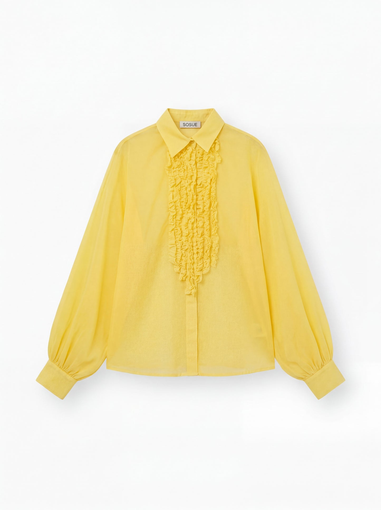 Die gelbe Bluse Antonia Slim Ruffle hat lange Ärmel, einen spitzen Kragen, eine geknöpfte Vorderseite, eine gerüschte Brustpartie und lose geraffte Manschetten. Das SOUGE Label ist auf der Innenseite des Kragens sichtbar.