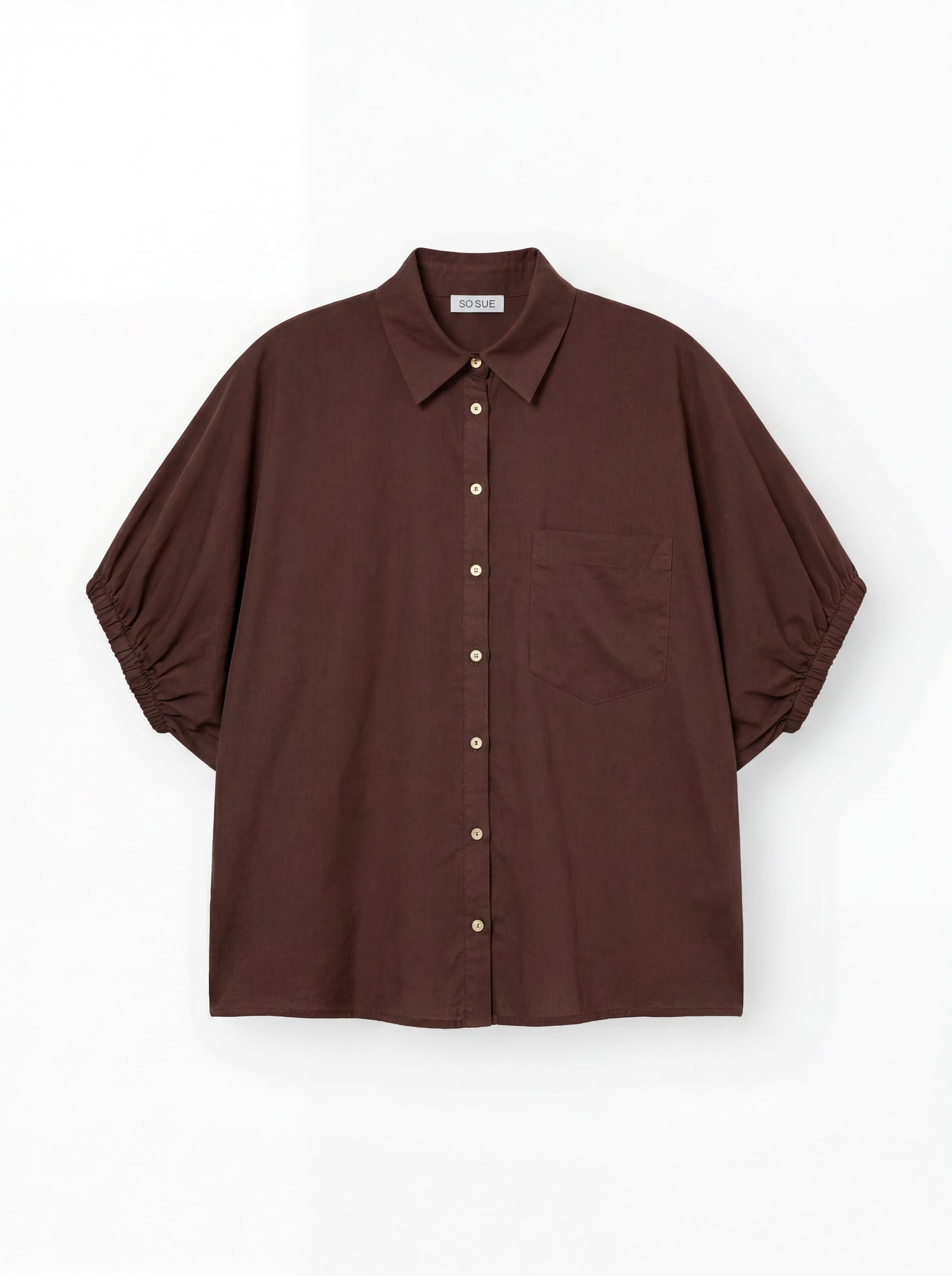 Das Cowboy Collar Voile Brown ist ein locker sitzendes, braunes Hemd zum Knöpfen mit Kragen, kurzen Puffärmeln, die an den Manschetten gerafft sind, und einer einzelnen Brusttasche, abgebildet auf einem schlichten weißen Hintergrund.