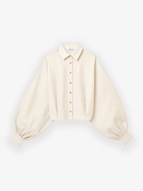 Die Bluse „Antonia Short Flanell Offwhite“ ist eine cremefarbene, langärmelige, kurz geschnittene Flanellbluse mit klassischem Kragen, Knopfleiste vorne und weiten Ärmeln, die an den Manschetten gerafft sind. Sie wird vor einem schlichten weißen Hintergrund gezeigt.