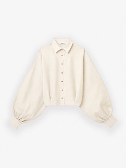 Die Bluse „Antonia Short Flanell Offwhite“ ist eine cremefarbene, langärmelige, kurz geschnittene Flanellbluse mit klassischem Kragen, Knopfleiste vorne und weiten Ärmeln, die an den Manschetten gerafft sind. Sie wird vor einem schlichten weißen Hintergrund gezeigt.