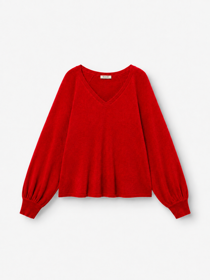 Ein langärmeliger Pullover „Antonia“ mit V-Ausschnitt in leuchtendem Rot, gefertigt aus luxuriöser Merinowolle und Kaschmir, mit weiten Ärmeln und gerippten Bündchen, abgebildet vor einem schlichten weißen Hintergrund.