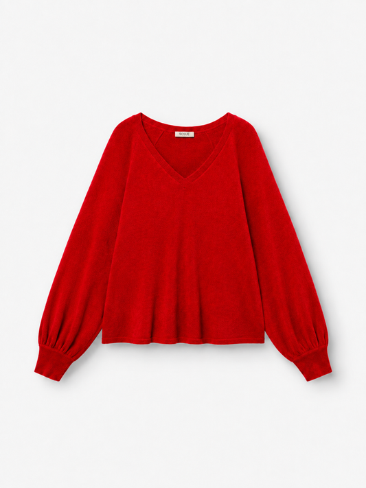 Ein langärmeliger Pullover „Antonia“ mit V-Ausschnitt in leuchtendem Rot, gefertigt aus luxuriöser Merinowolle und Kaschmir, mit weiten Ärmeln und gerippten Bündchen, abgebildet vor einem schlichten weißen Hintergrund.