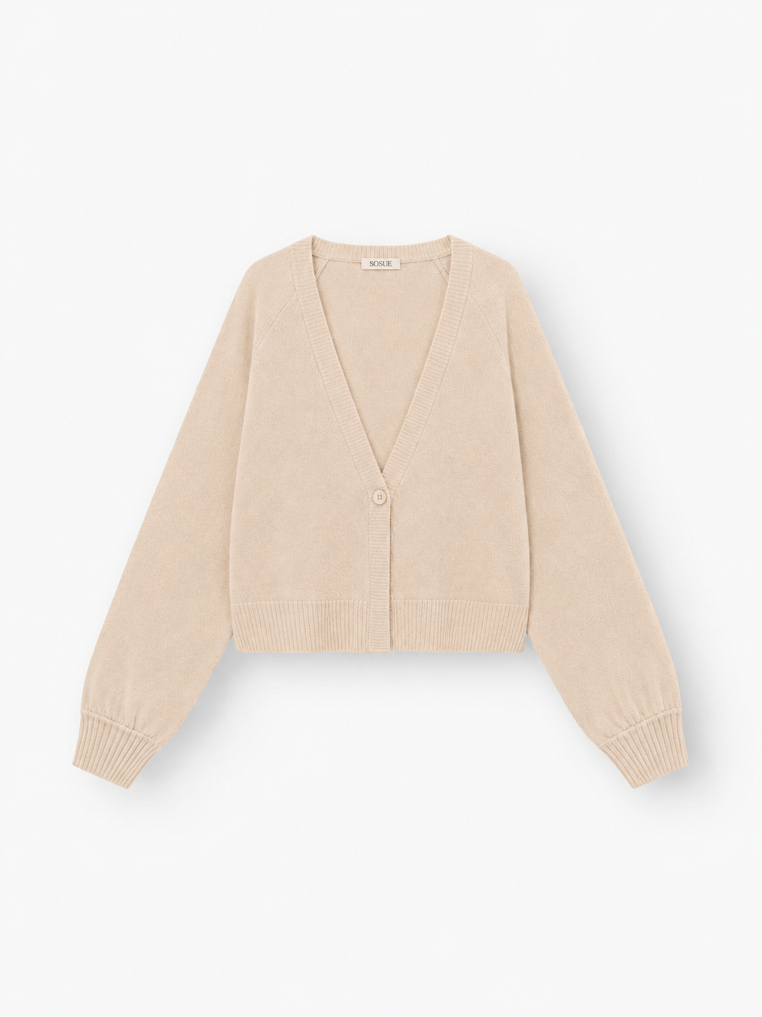 Die Antonia Short Cardigan Puder ist eine beigefarbene, langärmelige Damen-Strickjacke mit V-Ausschnitt, gerippten Bündchen und Saum sowie einem Ein-Knopf-Verschluss. Sie besteht aus einer luxuriösen Merinowolle-Kaschmir-Mischung und wird vor einem weißen Hintergrund präsentiert.